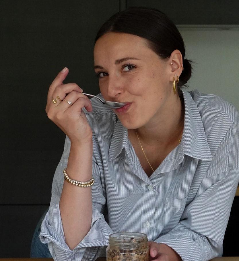 Une jeune femme en train de manger en souriant